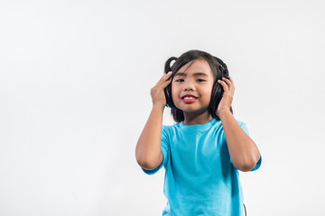 Little girl listening to music on wireless headphones
