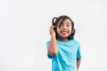 Little girl listening to music on wireless headphones