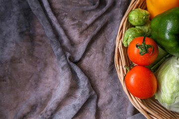 Top view of fresh vegetables in a wooden basket with copy space. 