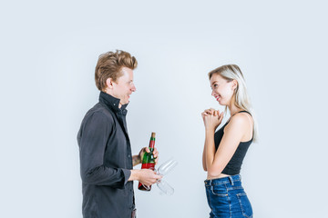 Portrait of happy young couple drinking wine in studio