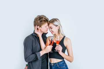 Portrait of happy young couple drinking wine in studio
