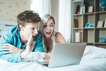 Happy couple Using laptop computer on the bed