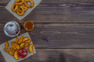 Snacks with beer on dark wooden background. Top view. Empty space for text