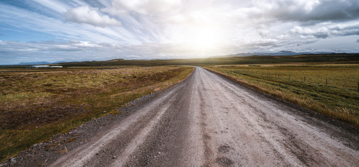 Empty gravel dirt road through countryside landscape and grass field. Nature off road travel trip for four-wheel-drive vehicle. © InfiniteFlow