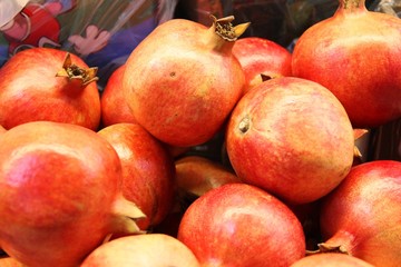 lots of red pomegranate fruits in the box, background. Good harvest garnet