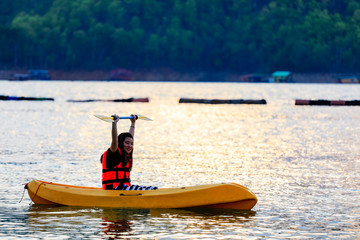 kayaking on the lake and sunset on behind the mountain background