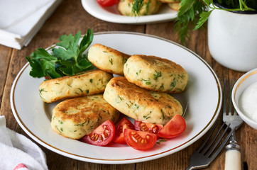 Fried potato cutlets with dill on a white plate
