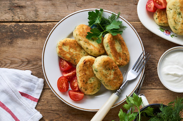 Fried potato cutlets with dill on a white plate