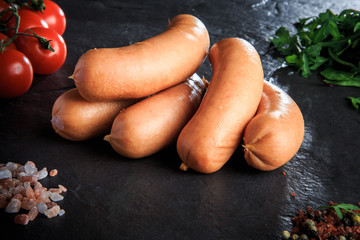 macro pile of raw short sausages with rucola and tomatoes