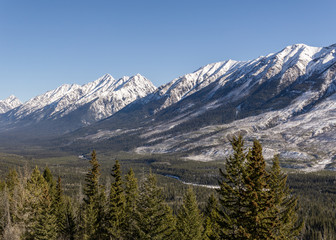 snow mountains peaks and forest landscape under sunlight early spring as background.