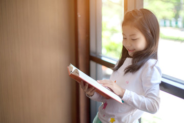student girl studying and reading book at home - education and school concept