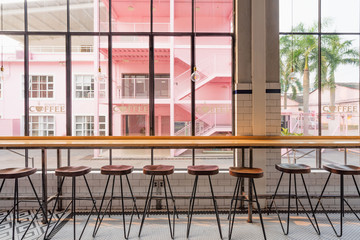 Naklejka premium A row of bar tables and chairs in front of the floor window in the dining room