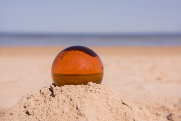 Glass sphere at the beach. Sunny summer day.