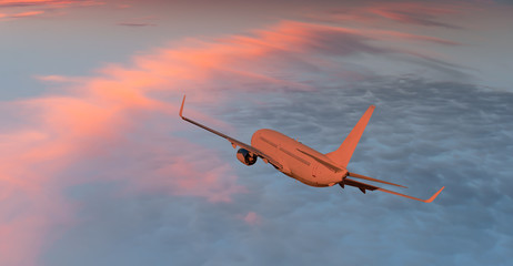 Airplane flying above tropical sea at sunset