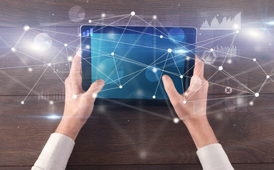 Hand using tablet with linking graphs charts  report and informational flow concept
