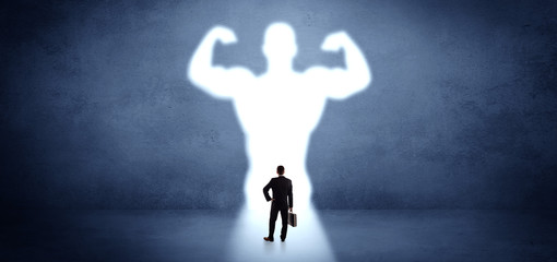Businessman standing and dreaming about a strong superhero
