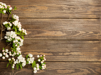 Flowering apple tree branch on wooden background. Spring concept. Flat layout. View from above. Copy space.