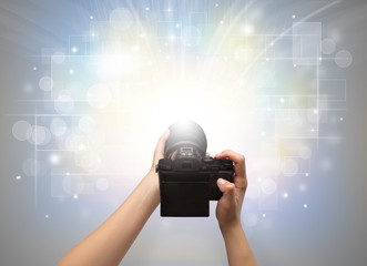 Naked hand taking picture with digital camera and glowing flash concept
