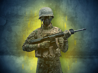 Fototapeta premium Hazard, menace soldier in a ruined crumbly building with arms on his hand 
