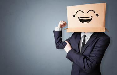 Funny man wearing cardboard box on his head with smiley face
