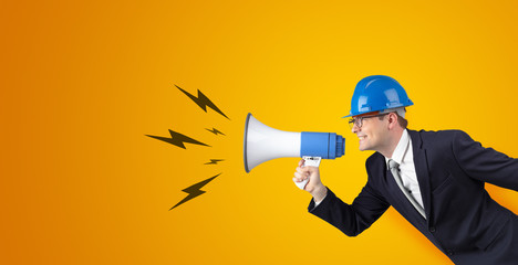 Fototapeta premium Young architect constructor yelling with megaphone and copyspace