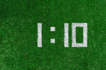 Football score 1:10.White numbers one and ten are drawn on the green grass