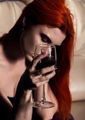 upset young woman in depression, holding glasses with wine. on a dating, waiting for a guy