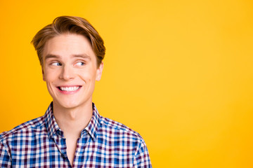 Close up photo amazing youngster he him his look side empty space silly playful mood white perfect teeth listening news wear casual plaid checkered shirt outfit isolated yellow bright background