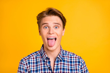 Handsome guy showing tongue isolated bright background