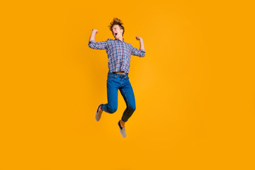 Full length body size view portrait of his he nice attractive cheerful cheery optimistic guy in checked shirt having fun flying isolated over bright vivid shine yellow background