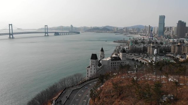 Aerial view of the road in the hills on Dalian, China. A popular tourist travel destination in Asia. Long bridge in the background over the sea.