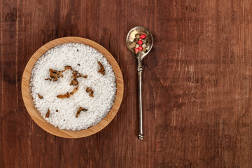Gourmet spices. A bowl of sea salt infused with truffle shavings, and a pepper mix, shot from the top on a dark rustic wooden background with a place for text