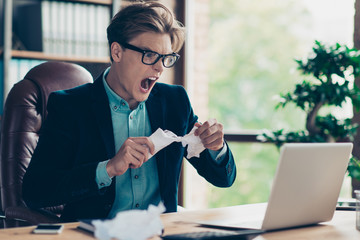 Portrait negative handsome frustrated guy hold hand paper work squeeze shred shout sheets...