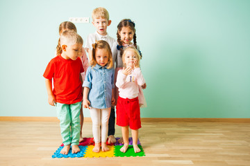 Group of kids stands on massaging mats