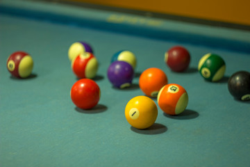 bright blurry old shabby multi-colored billiard balls on blue cloth