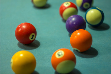 blurry old shabby multi-colored billiard balls on blue cloth