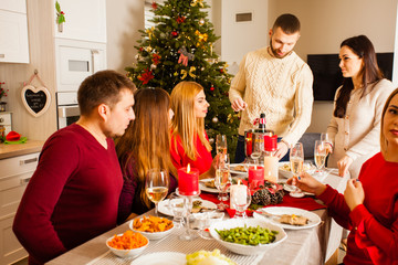 Group of people celebrating New year around table