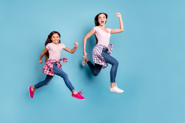 Fototapeta na wymiar Full length body size view portrait of two nice attractive cheerful cheery ecstatic straight-haired girls hipster outfit running fast isolated on bright vivid shine blue turquoise background