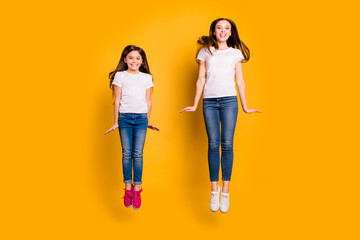 Fototapeta premium Full length body size photo beautiful her she different age diversity ladies weekend spend free time jump high carefree having fun wear casual white t-shirts jeans denim isolated yellow background
