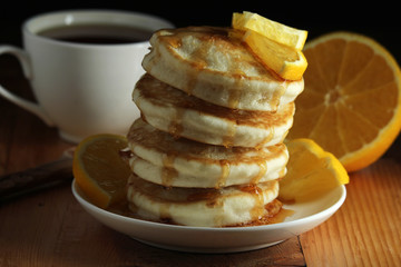 A stack of freshly backed pancakes and a cup of coffee