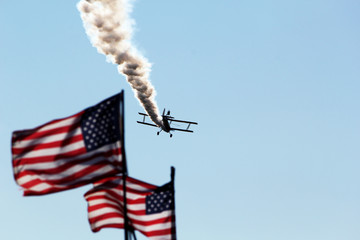 american flags with airplane in sky