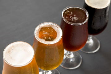 Cold craft beer assortment on a black background, low angle view. Close-up.
