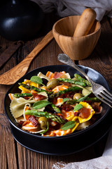 Pasta salad with green asparagus, olives and parma ham