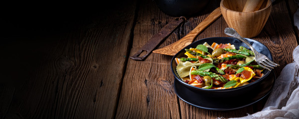 Pasta salad with green asparagus, olives and parma ham