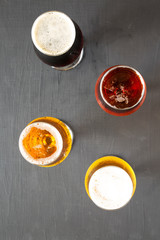 Cold craft beer assortment on a black surface, top view. Overhead, from above.
