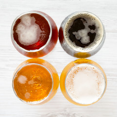 Craft beer assortment on a white wooden background, top view. Overhead, from above, flat lay.