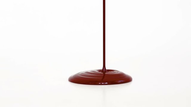 Melted chocolate syrup on white background.