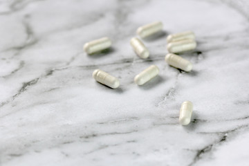 Fototapeta na wymiar closeup of cbd pill capsules on marble background