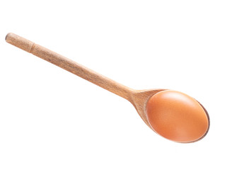 Brown egg on wooden spoon isolated on white.