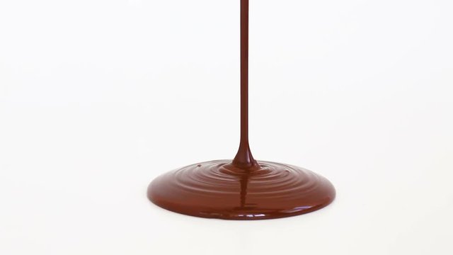 Melted chocolate syrup on white background.